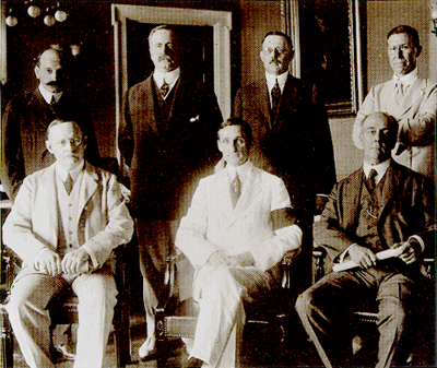 First Board of Governors of the Federal Reserve System. Seated: Charles S. Hamlin, William G. McAdoo, Frederic A. Delano. Standing: Paul M. Warburg, George Skelton Williams, W.P.G. Harding, Adolph C. Miller.