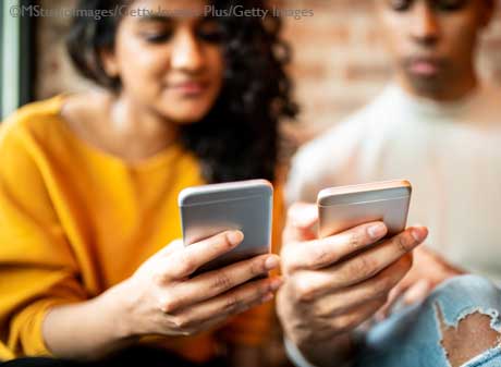 Young woman and man using P2P mobile pay with smartphones