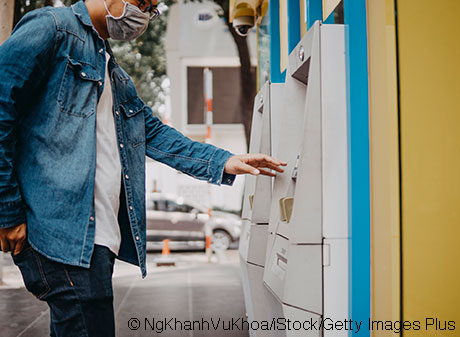 Man with covid mask on at an ATM