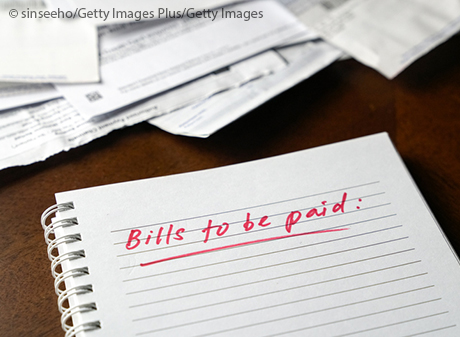 Stock image of bills to paid written on notebook