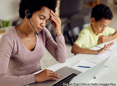 Black mom has headache while working and helping son with homework