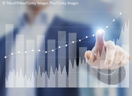 Stock Image - Businessman using business intelligence to sketch success on charts