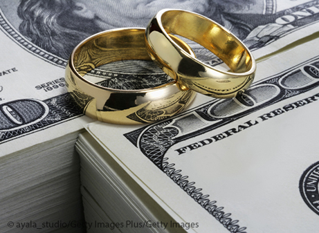 wedding rings on stack of money