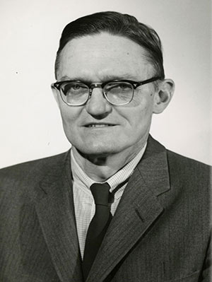 Black and white picture of white male in glasses and business attire