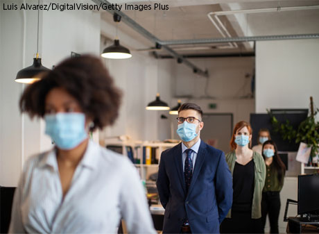 People social distancing in a work environment.