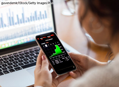 Young adult analyzes financial charts on smart phone.