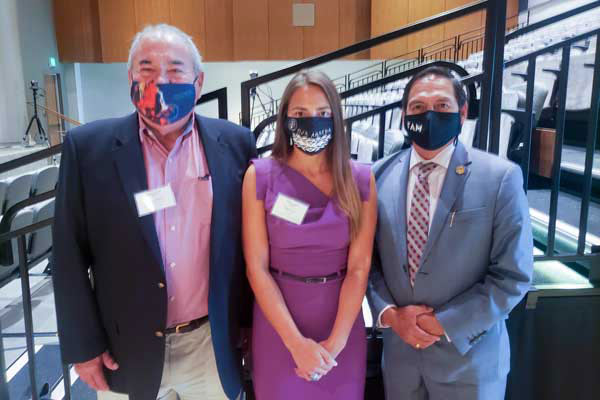 Three people wearing masks standing in a college lecture hall