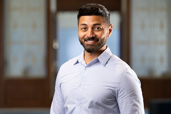 Head and shoulders portrait of a man in front of blurred background.