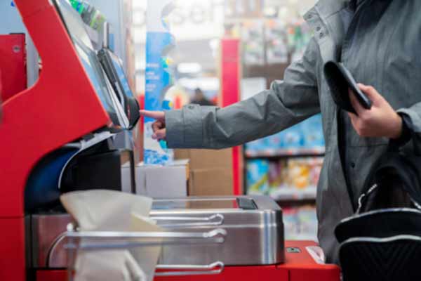 A person goes through a self-service kiosk at a grocery store