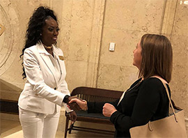 The St. Louis Fed's Monica Buren, left, shakes hands with a supplier.