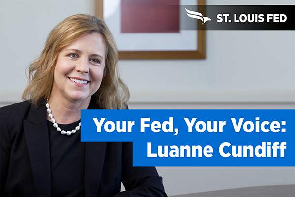 Luanne Cundiff smiles next to a 'Your Fed, Your Voice' banner.
