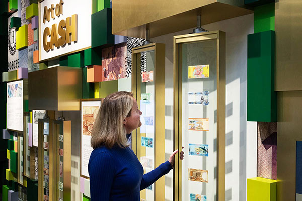 A woman observes a display of money from different countries.