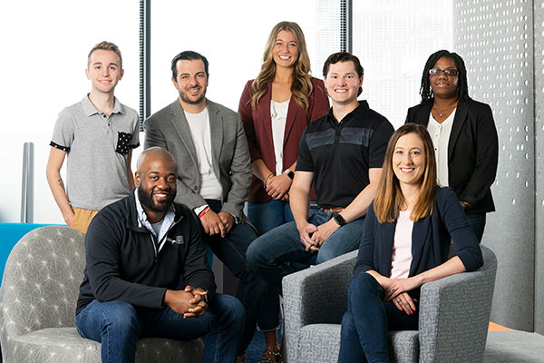 A group of seven young professionals in business casual attire.