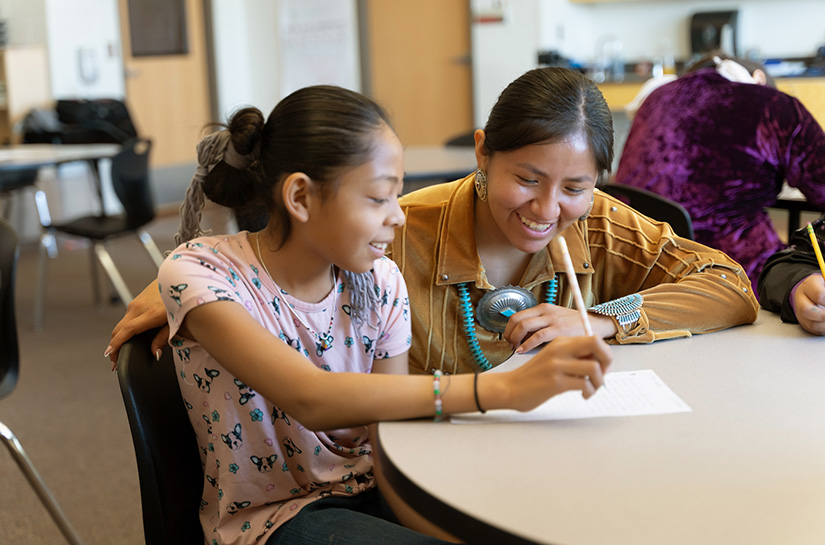 A teacher works closely with a student.