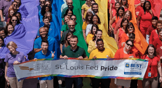 Large group of people dressed in purple, blue, green, yellow, orange or red.