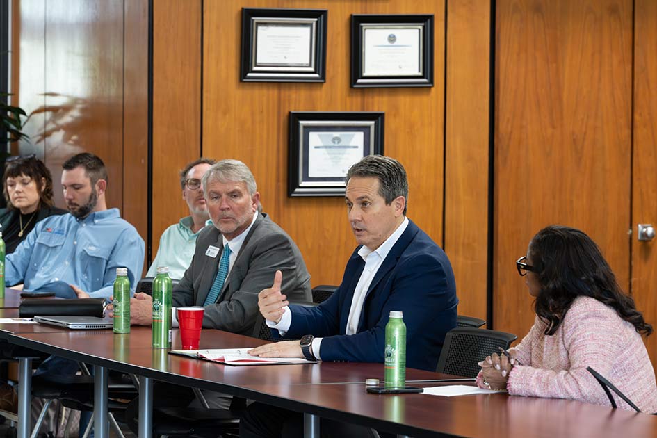 Musalem speaks to a group of people seated at a table.