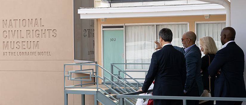 Musalem and three other people stand outside a building that has the inscription ‘National Civil Rights Museum at the Lorraine Motel.