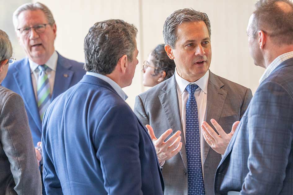 St. Louis Fed President Alberto Musalem and Kansas City Fed President Jeff Schmid talk with people in business attire.