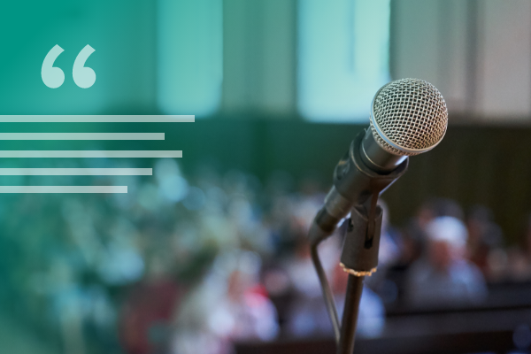 decorative image of a microphone overlooking a seated audience