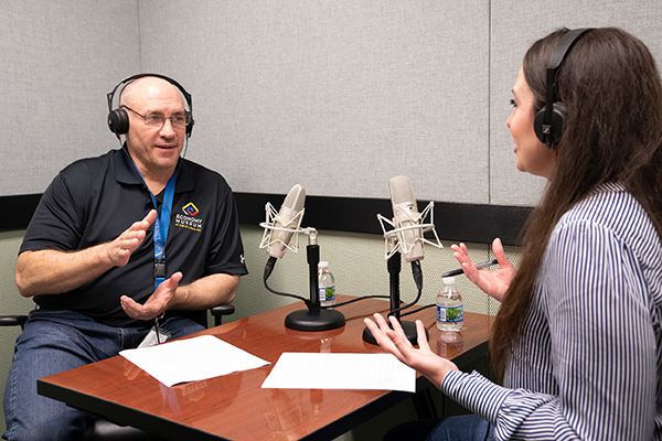 Chris Neely in the recording studio, speaking with host Laura Taylor.