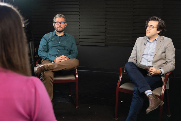 Two men seated in a studio.