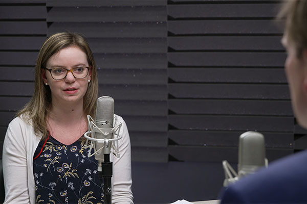 Victoria Gregory speaking into a microphone in a recording studio.