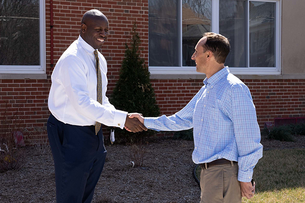 Two men in business attire shaking hands