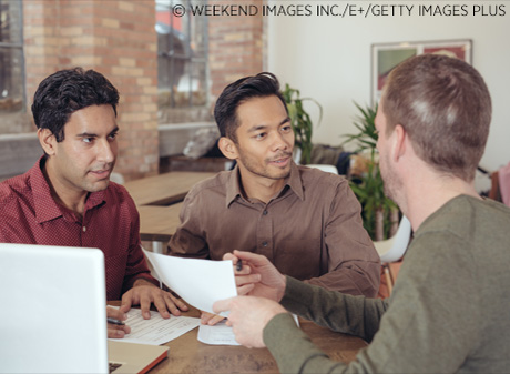 A couple gets information on mortgage rates from a financial adviser.