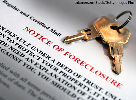 Set of house keys laying on top of home foreclosure papers