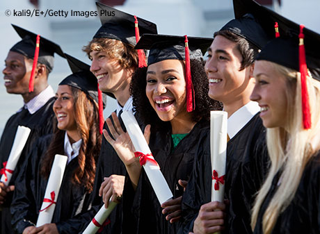 A line of smiling graduate students with diplomas.