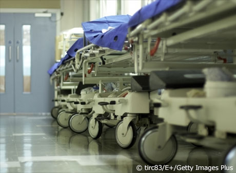 row of empty hospital beds in hallway
