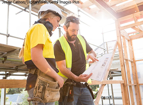 Man and Woman Looking at Construction Plans at Construction Site.