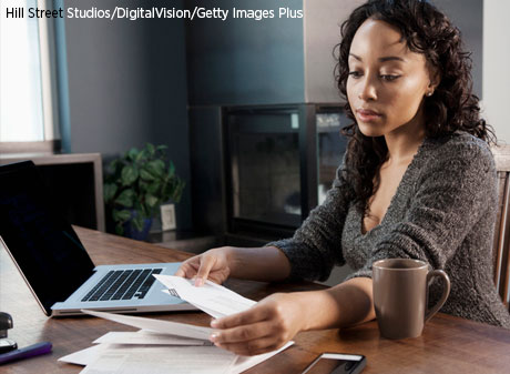 Black woman paying bills on computer