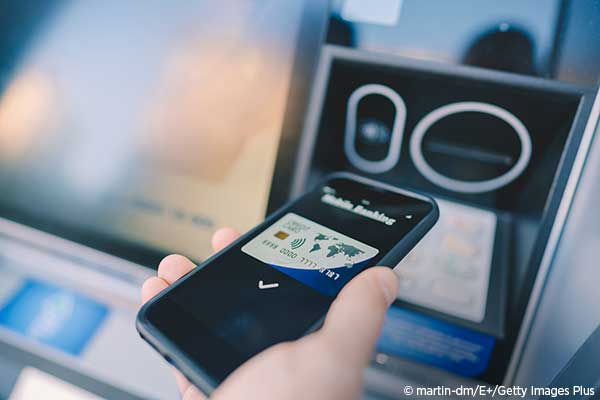 Man at an ATM withdrawing Money on Smartphone.