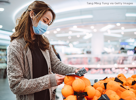 Woman checks price of oranges
