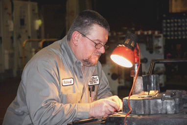 At Bedford Machine & Tool Inc., Richard Hawkins polishes steel inserts for a die.