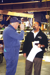 Dave Hunt (left), a skilled maintenance worker, confers on the floor with the GM plant’s finance manager, Glenn Sampson.