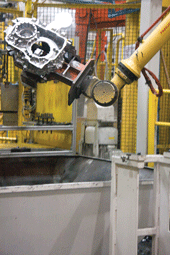 At the GM plant, a robot removes a die-cast transmission housing from one of those machines.
