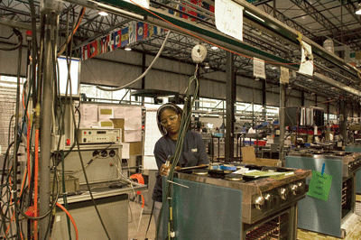 At one of the Viking factories in town, employee Latonja Harris gives a final inspection to a range. | St. Louis Fed