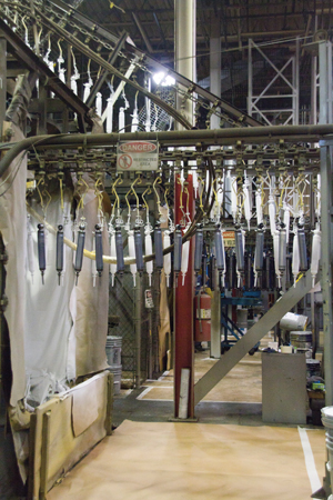 Shock absorbers enter a water-based electrostatic paint booth.
