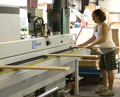 At Institutional Casework Inc., Candace Steele works a machine that sizes, glues and trims the edging of doors and drawers. | St. Louis Fed