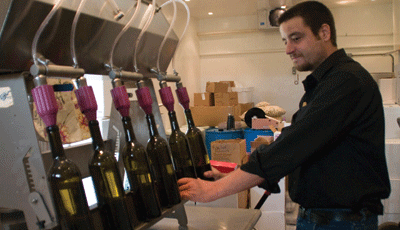 Nathan Young Jr. fills bottles at the newly opened Paris Winery. | St. Louis Fed