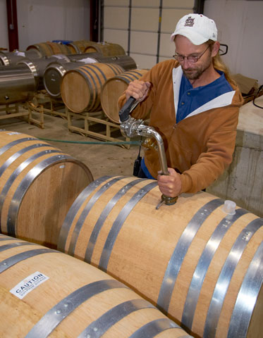 Jimmy Bailey checks on a barrel of wine at St. James Winery.