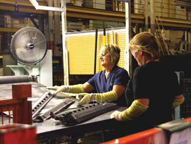 At Tower Automotive employees Rosemary May (left) and Annie Skaggs inspect stamped components for a Nissan Altima door.