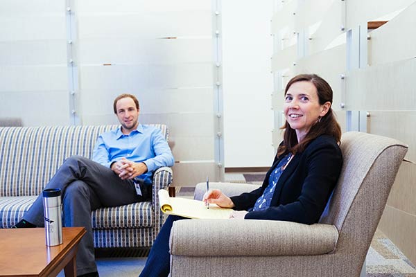 Two economists sit in informal meeting area.
