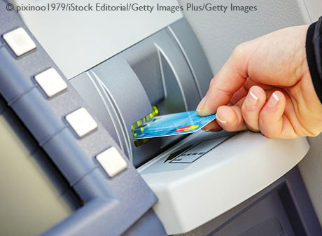 woman uses ATM machine