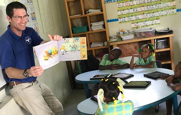 Kris Bertelsen of the St. Louis Fed reads to students in Haiti