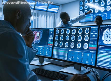 Medical Scientist Working with CT Brain Scan Images on a Personal Computer in Laboratory.