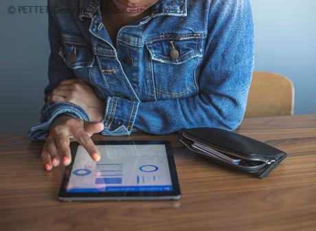 Young woman reviewing accounts on tablet