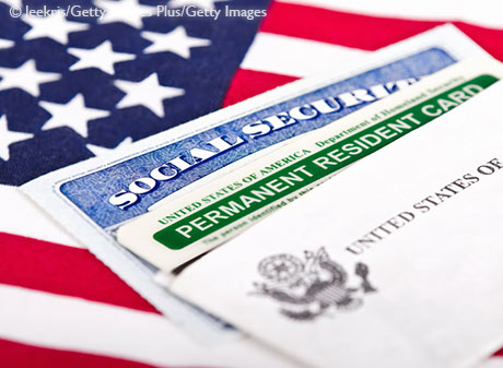 Stock photo of Social Security card and permanent resident on USA flag